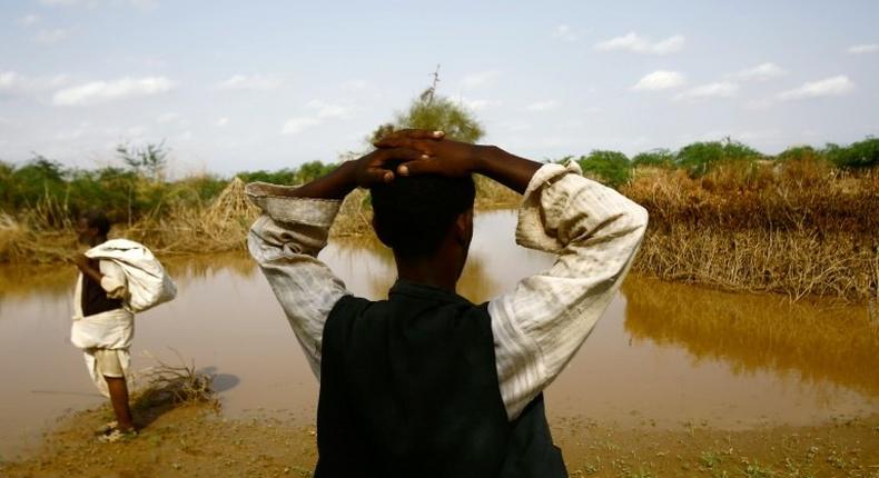 A Sudanese man looks at the river Gash that burst its banks flooding the village of Makli on August 14, 2016, destroying thousands of houses and submerging several villages 