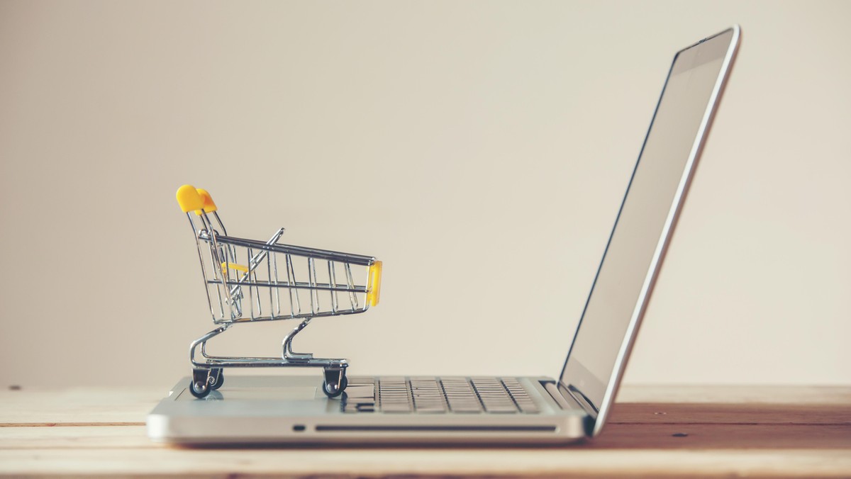 Small Shopping Cart On Laptop With Copyspace : Online Shopping Concept. E-commerce.