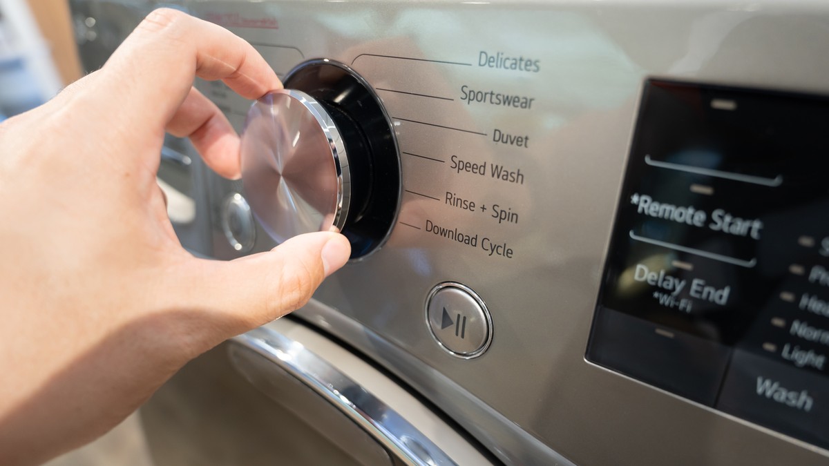 Adjusting,Washing,Machine,Setting.,Hand,Turning,The,Dial,Of,A