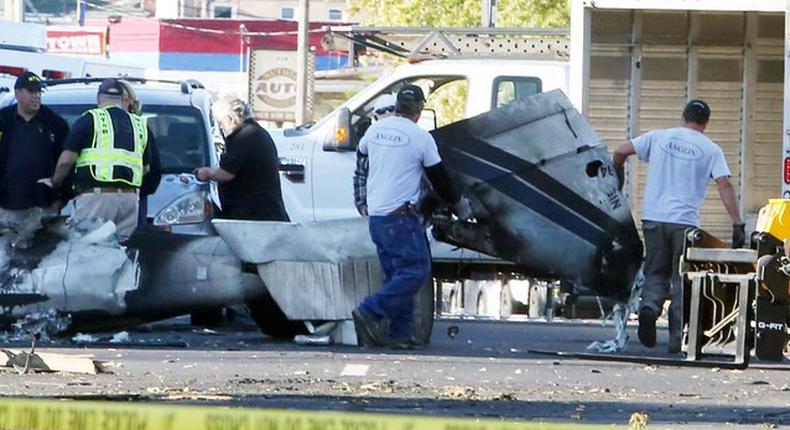 Wreckage is removed from the scene of a twin-engine plane that struck a utility pole and burst into flames in downtown East Hartford, Connecticut U.S., October 12, 2016.