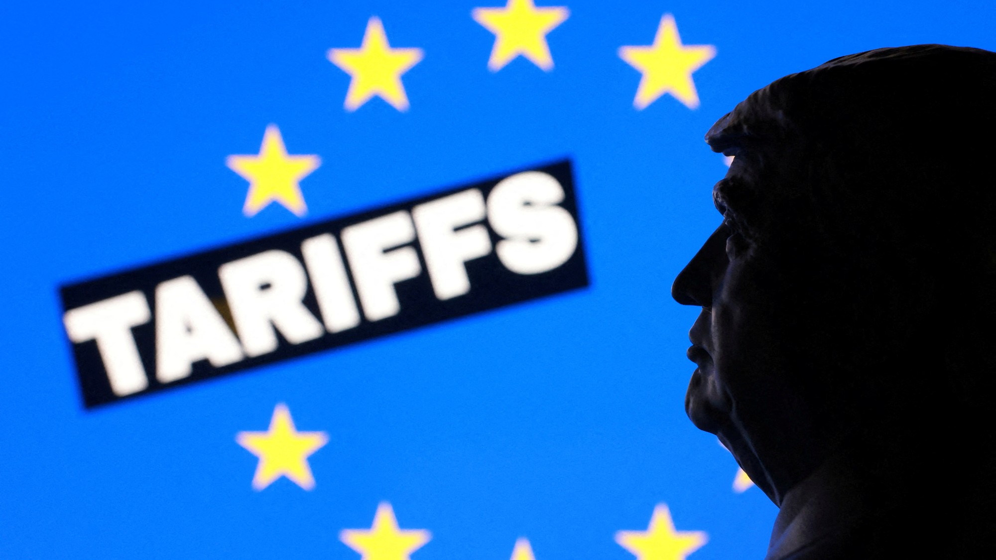 Ilustrácia zobrazuje miniatúrny model amerického prezidenta Donalda Trumpa, vlajku EÚ a slovo „Clá“