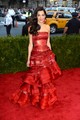 2015 - Első Met-gáláján Amal Clooney a Maison Margiela kreatív igazgatója, John Galliano egyedi karmazsinszínű ruhájában lépett a vörös szőnyegre. A kézzel festett és hímzett selyem organza dizájn pánt nélküli míderrel, és lépcsőzetes szoknyával készült. 