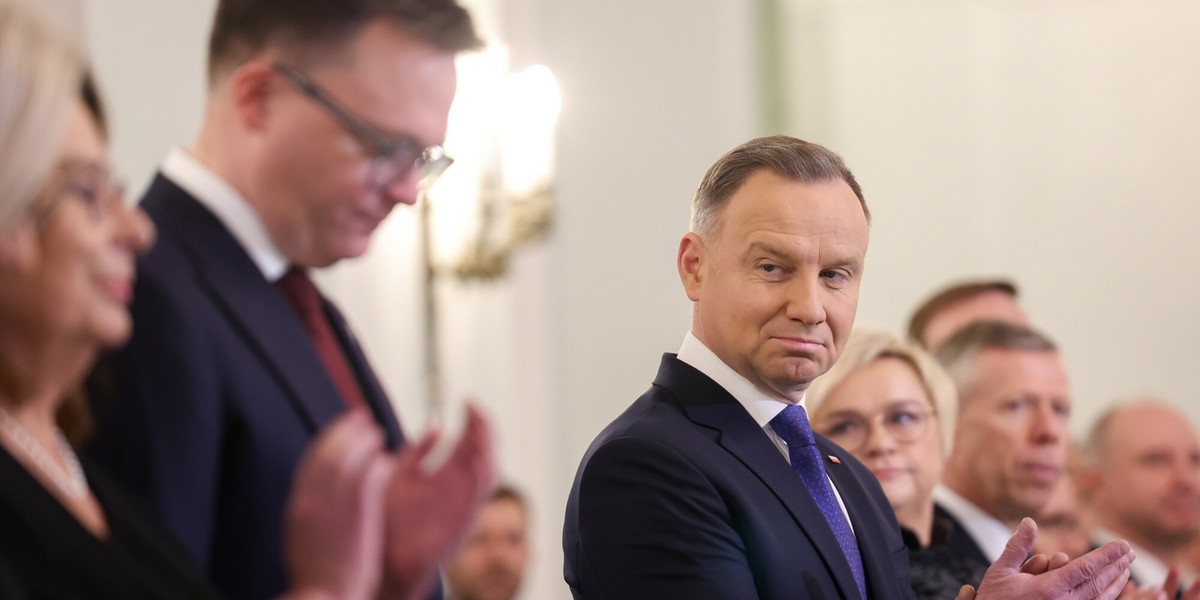 Prezydent Andrzej Duda spoglądający w kierunku Szymona Hołowni