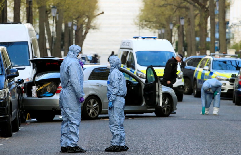 Police forensics officer works at the site where police fired shots after a vehicle rammed the parke