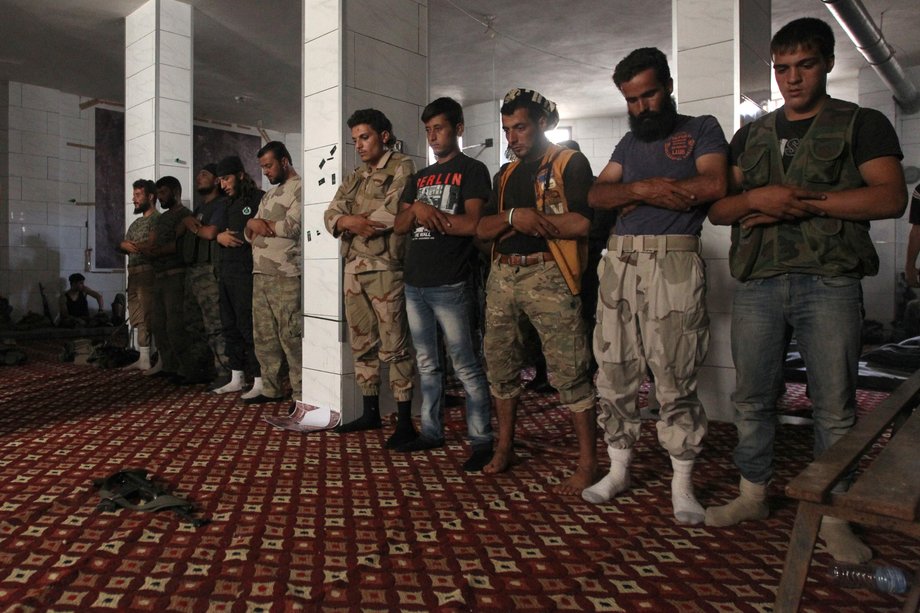 Rebel fighters praying inside a safe house in the rebel held al-Rashideen neighborhood in Syria's western Aleppo province on Sunday.