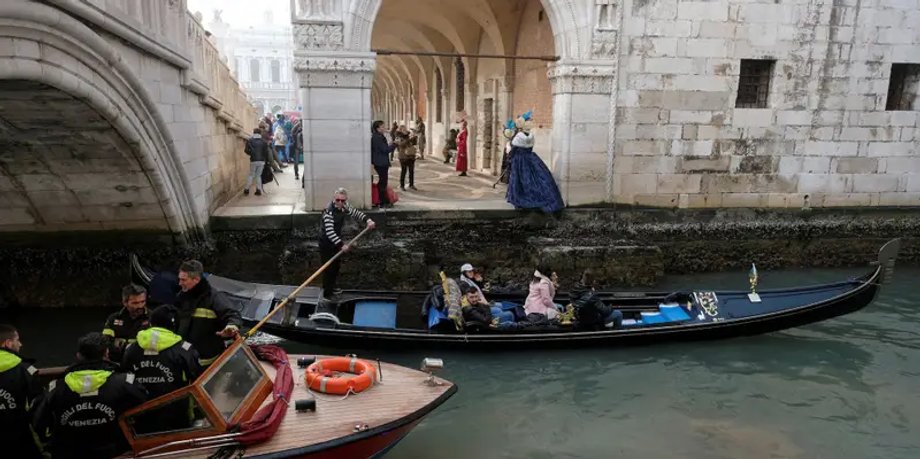 Łódź strażacka i gondola przepływająca kanałem podczas silnego odpływu w Wenecji/ Manuel Silvestri/Reuters