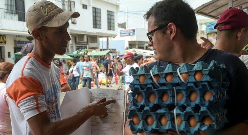 Giovanni Jose Plaza (L), a Venezuelan migrant suffering from AIDS, asks passersby in the border town of Cucuta, Colombia for money to buy medications