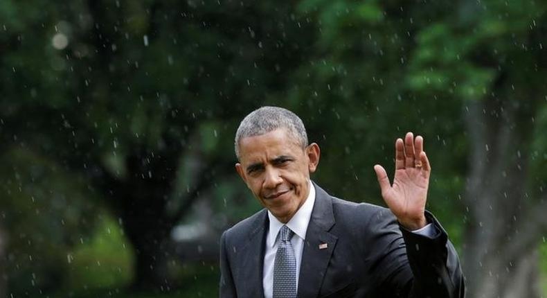 U.S. President Barack Obama waves as he walks under a rain on the South Lawn of the White House upon his return to Washington, U.S., after visiting wounded service members the Walter Reed National Military Medical Center, June 21, 2016. REUTERS/Yuri Gripas