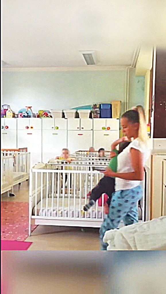Medicinska sestra ulazi u sobu, a mališana grubo drži jednom rukom  