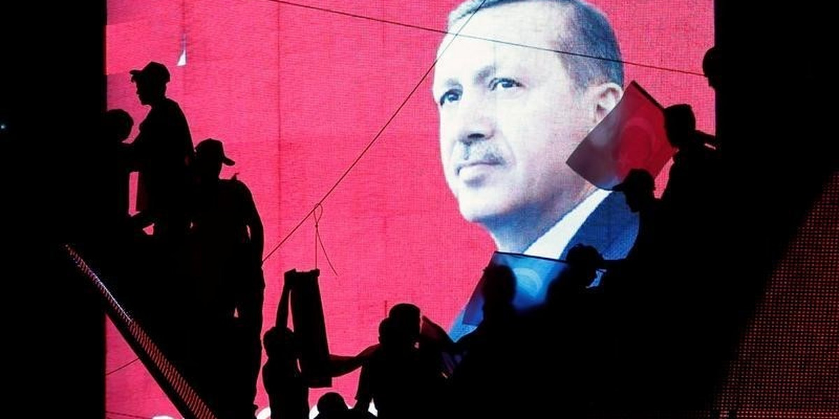 Turkish Supporters are silhouetted against a screen showing President Tayyip Erdogan during a pro-government demonstration in Ankara