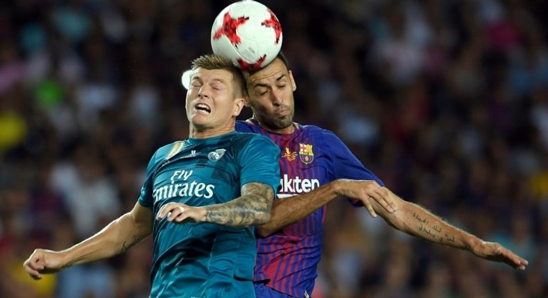 Barcelona's Sergio Busquets (R) fights for the ball with Real Madrid's Toni Kroos during their Spanish Super Cup first leg match, at Camp Nou in Barcelona, on August 13, 2017