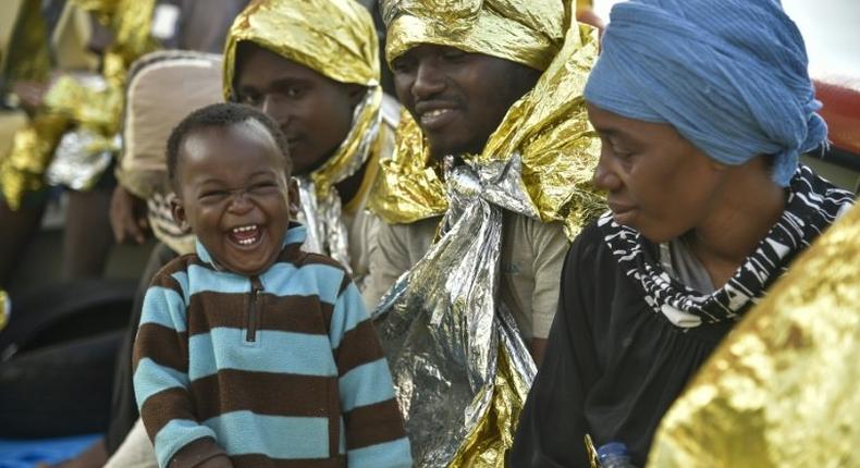 A baby laughs after being rescued at sea