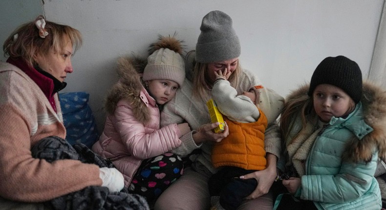 Women and children sit on the floor of a corridor in a hospital in Mariupol, eastern Ukraine Friday, March 11, 2022..