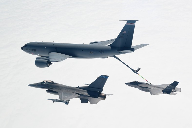 Norweski samolot F-35 w trakcie pobierania paliwa z amerykańskiej latającej cysterny Boeing KC-135 Stratotanker. Samolotom towarzyszy należący do U.S. Air Force myśliwiec F-16.