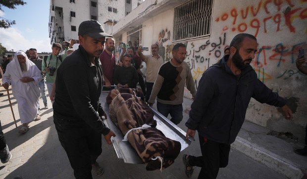 Palestinci nose telo osobe poginule u izraelskim vazdušnim napadima u petak, usmerenim na Iza al Dina al Hadada, vođu Hamasa