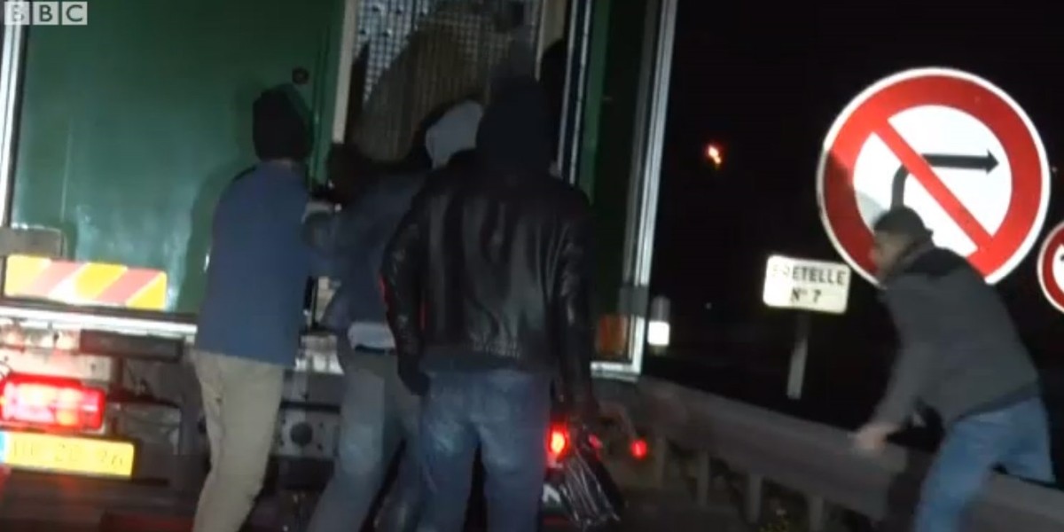 Imigranci forsują drzwi ciężarówki w Calais.