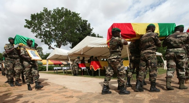 Malian army officers carry a coffin on July 21, 2016 in Segou during a funeral ceremony 