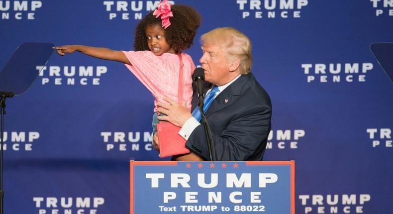 Republican presidential nominee Donald Trump holds a child as he speaks during a rally at the KI Convention Center on October 17, 2016 in Green Bay, Wisconsin