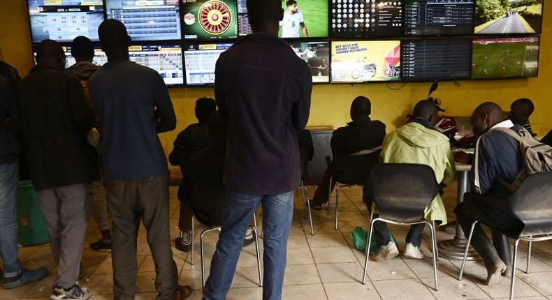 Sports enthusiasts watch different games on screens while betting at a sports betting shop in July 15, 2019 in Nairobi.  (Photo by SIMON MAINA/AFP via Getty Images)