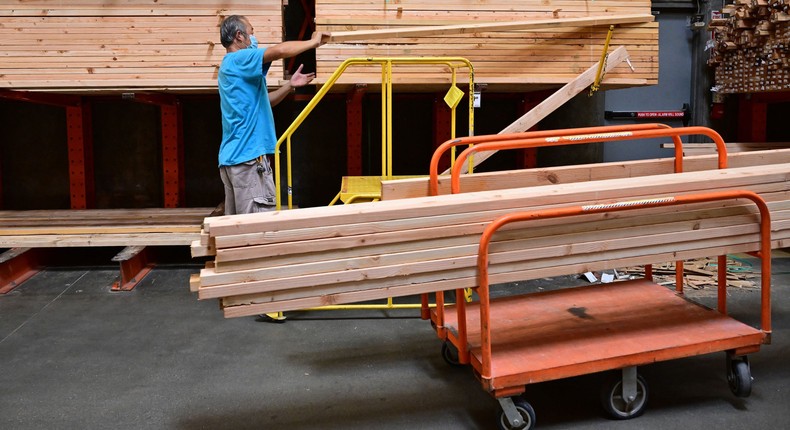 A man loads pieces of two-by-four wood onto his cart in the lumber section at a home improvement store on August 16, 2022 in Alhambra, California.FREDERIC J. BROWN/AFP via Getty Images