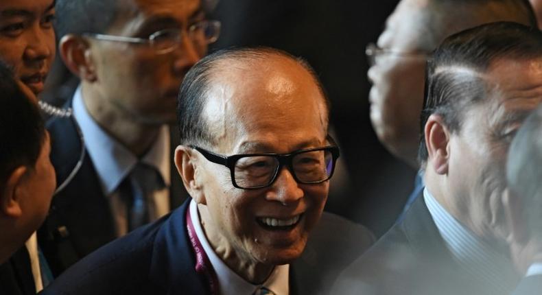 Hong Kong tycoon Li Ka-shing (C) said he was cautiously optimistic about his company's future, as an upturn in major economies was weighed by geopolitical risks