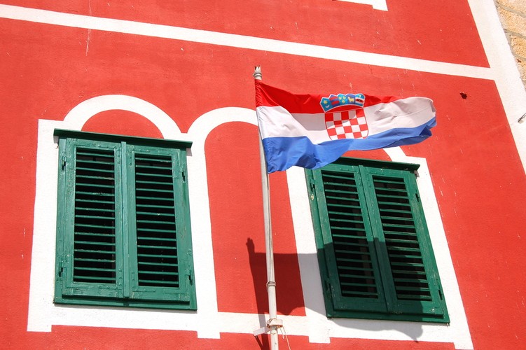 A gdzie na wakacje Polacy pojadą samochodem? Według statystyk biura Neckermann Polacy, którzy nie decydują się podróż samolotem ani autokarem najchętniej wybierają Chorwację, Bułgarię i Włochy. To najbliżej położone kraje południowe. Podróż samochodem do każdego z krajów trwa około dwóch dni. Szacunki PZOT wskazują na to, że w sezonie 2011/2012 za granicę ogółem wyjedzie o 12 proc. więcej Polaków niż rok temu. Na zdjęciu: Chorwacja - flaga na fasadzie budynku