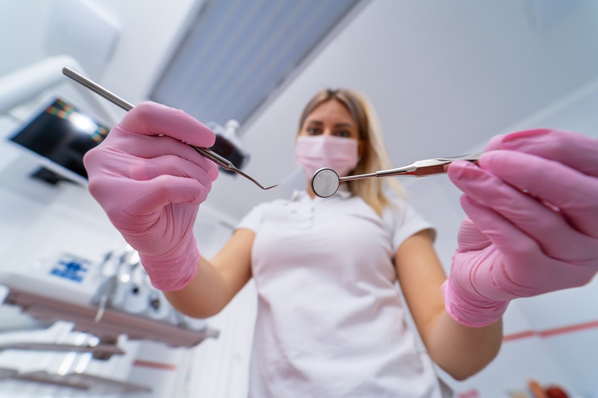 Dentystka podczas badania w gabinecie stomatologicznym – leczenie na NFZ w 2025 roku