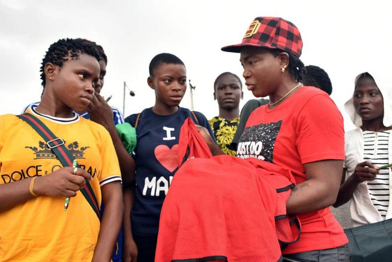 Ayisat Yusuf-Aromire giving a sweater to the girls