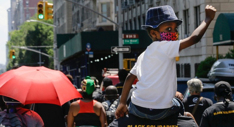 A man carries a child on his shoulders as they march near Central Park during a 2020 Juneteenth celebration.Frank Franklin II/Associated Press