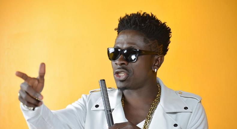 Shatta Wale holding a microphone