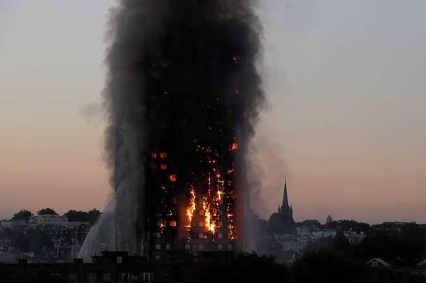 Flames and smoke billow as firefighters deal with a serious fire in the Grenfell Tower apartment blo