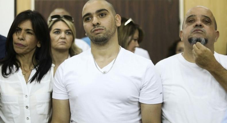 Israeli soldier Elor Azaria, who shot dead a wounded Palestinian assailant in March 2016, stands between his mother Oshra and father Charlie at a military court in Tel Aviv, on July 30, 2017