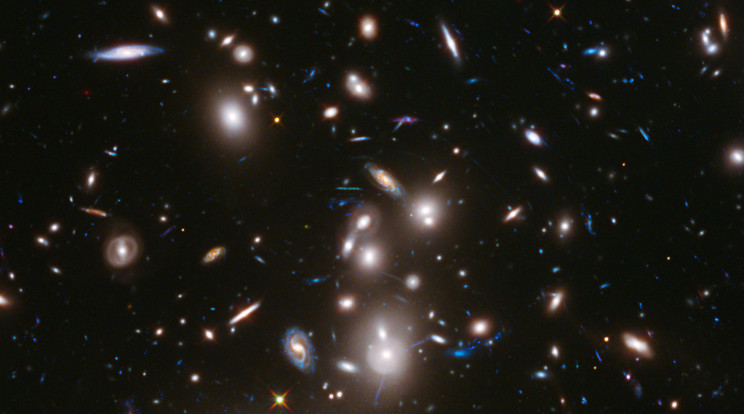 A Hubble űrteleszkóp felvétel a hatalmas Abell 2744  galaxishalmazról, amely a világűrben valaha észlelt leghalványabb és legfiatalabb galaxisok közül is tartalmaz néhányat. Több száz galaxis terelődött itt össze. A fotó azt mutatja, ahogyan 3,5 milliárd évvel ezelőtt kinéztek. Az Abell 2744 óriási gravitációs lencseként működik, amely eltorzítja a teret, valamint kivilágosítja és felnagyítja közel 3000 távoli háttérgalaxis képét. A távolabbi galaxisok ugyanúgy jelennek meg, mint 12 milliárd évvel ezelőtt, nem sokkal az ősrobbanás után. / Fotó: NASA, ESA, Jennifer Lotz (STScI), Matt Mountain (STScI), Anton M. Koekemoer (STScI), HFF Team (STScI)