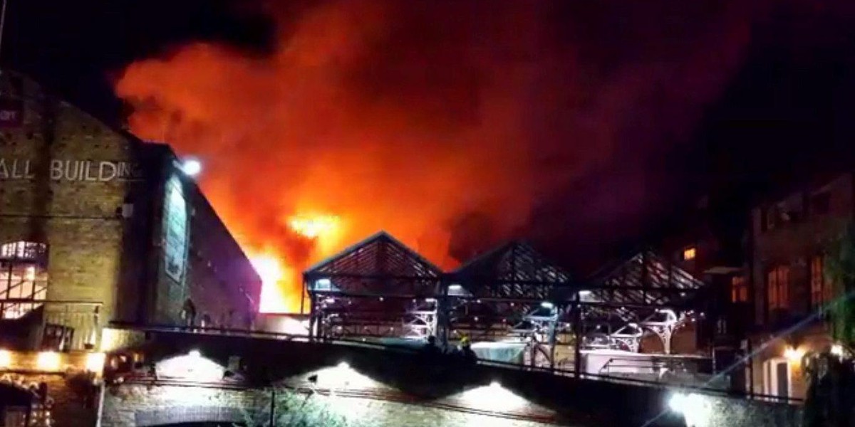 Firefighters spray water onto a fire at Camden Market in London