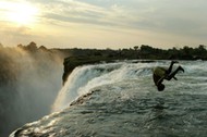 A Zambian man somersaults into a pool at the edge of the 110 metre high main falls of the Victoria F