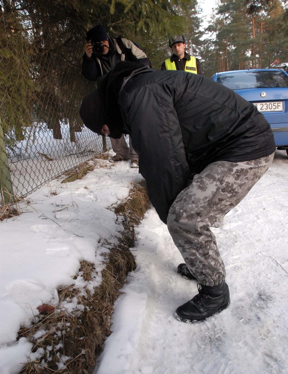 Policjant zabezpiecza naboje znalezione na miejscu strzelaniny między policjantami a dwoma bandytami ukrywającymi się w domu w Magdalence