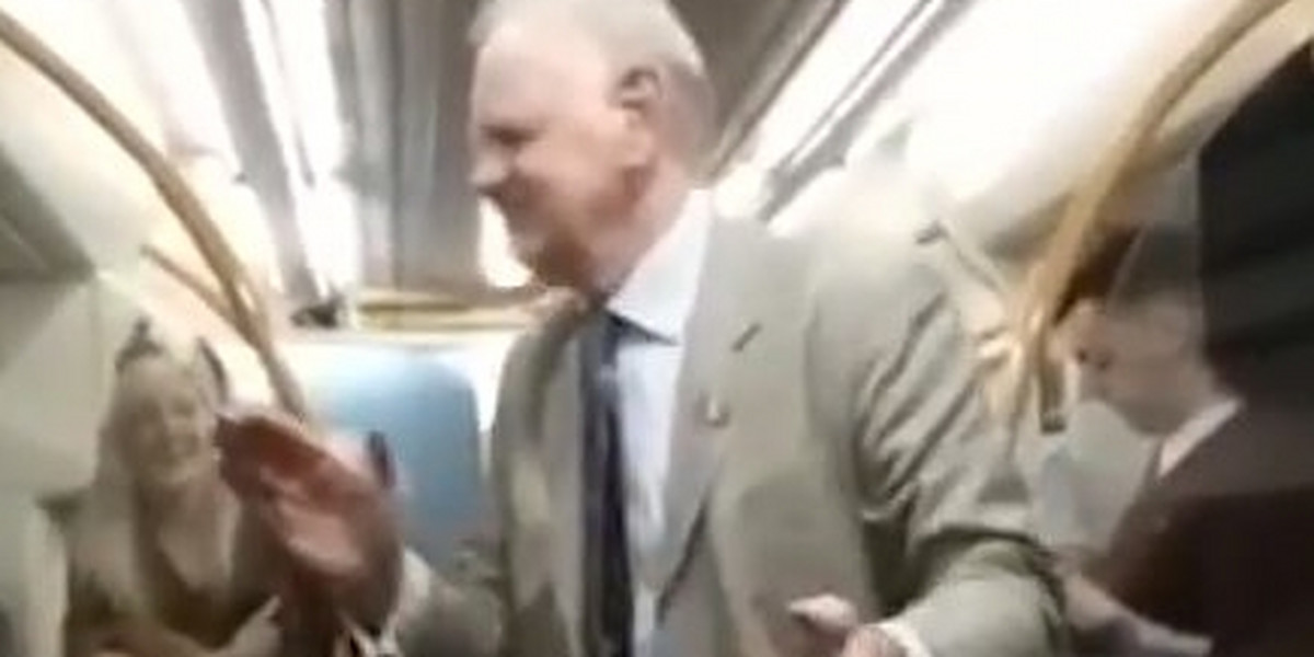 Dziadek rozkręca pasażerów w pociągu.