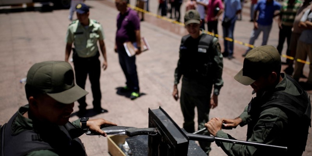 Venezuelan national guardsmen destroy a weapon during an exercise to disable seized weapons in Caracas.