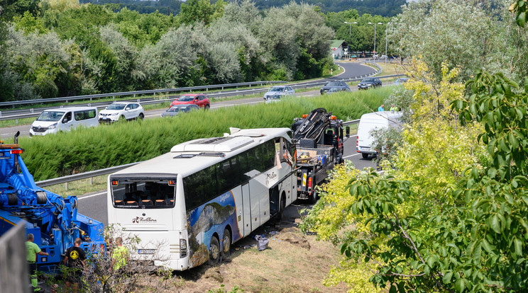Elvontatják a hajnalban árokba hajtott autóbuszt az M7-es autópálya mellett Szabadbattyán közelében / Fotó: MTI/Vasvári Tamás