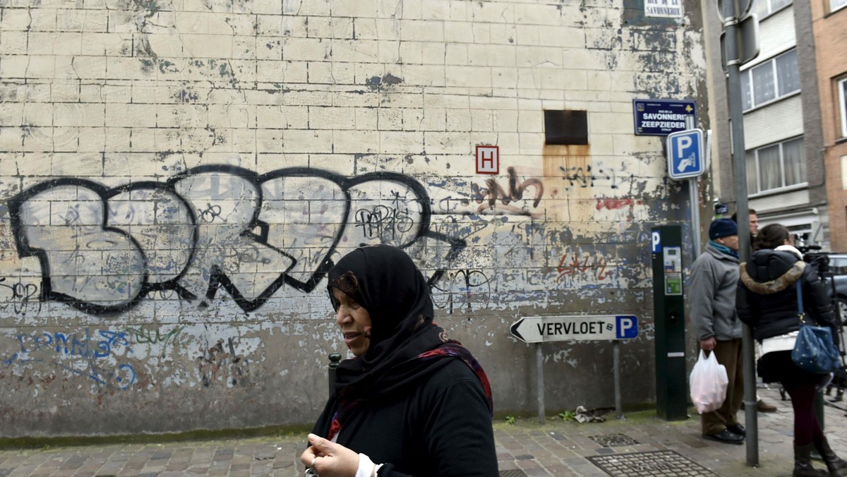 A woman passes close to the house where Salah Abdeslam was arrested after a shootout with police in 