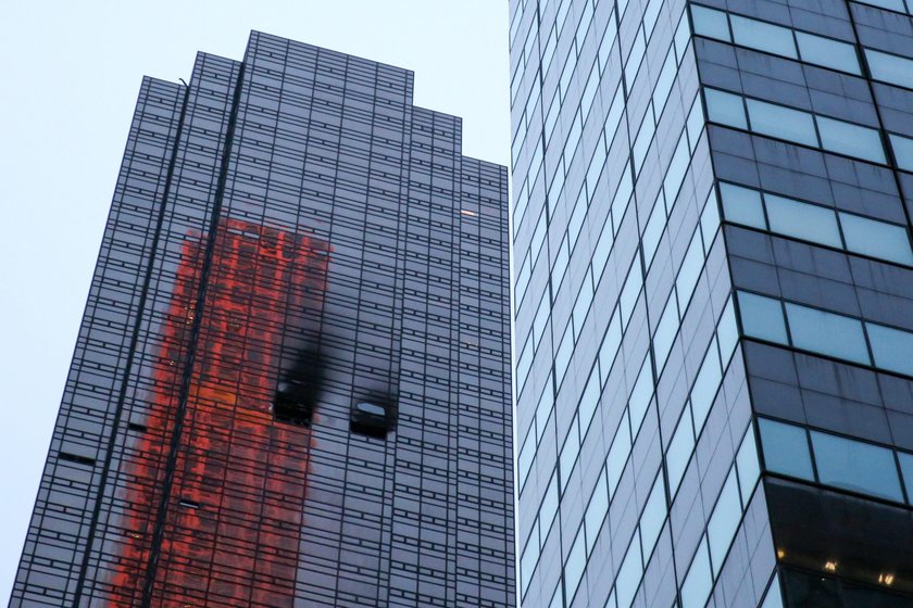 Damaged windows are seen after a fire in a residential unit at Trump Tower in New York