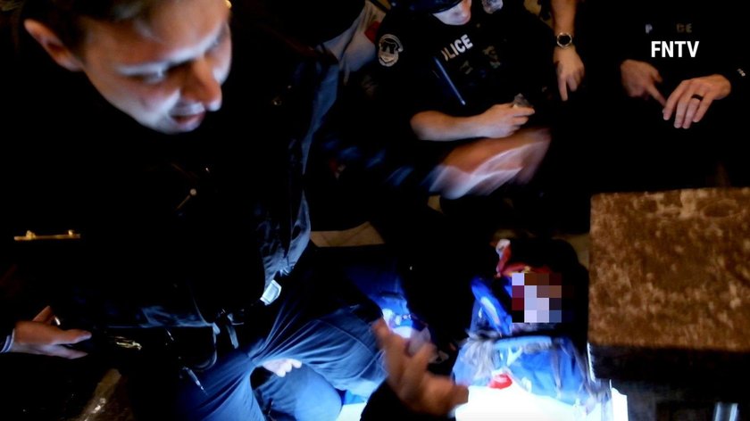 People and police help a woman, who was shot, as she lies on the floor, after supporters of U.S. Pre