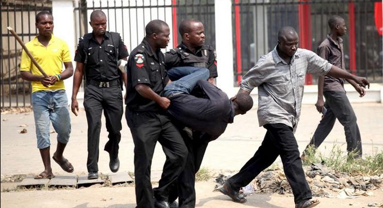 Policemen carrying a suspect (for Illustrative use)