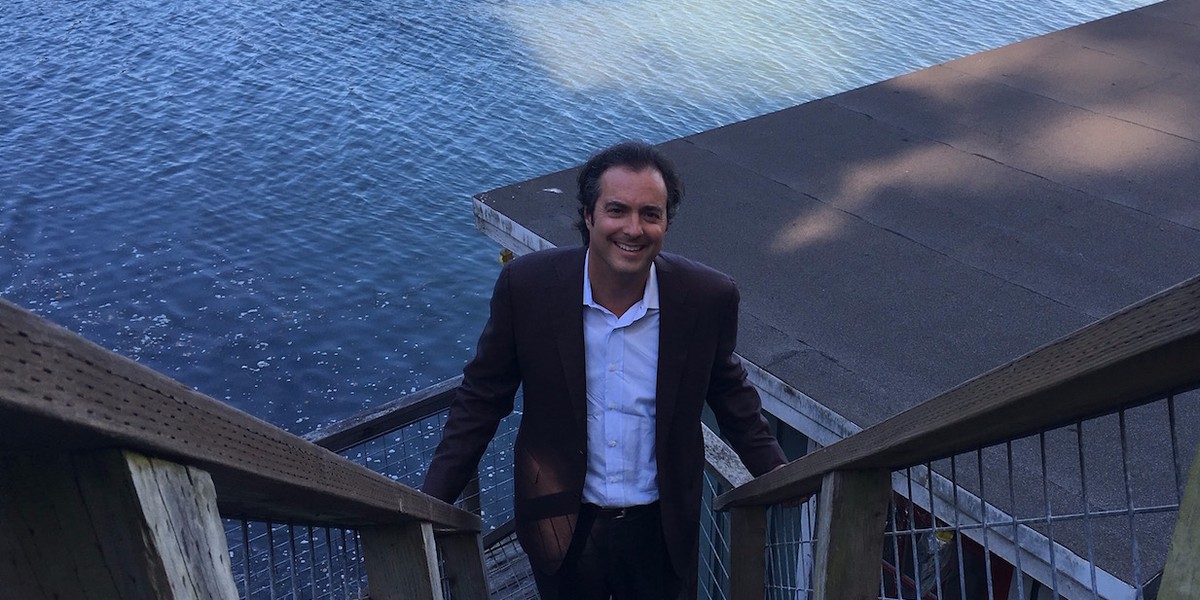 Jon Fisher, CEO of CrowdOptic stands on the stairs leading to his boat house