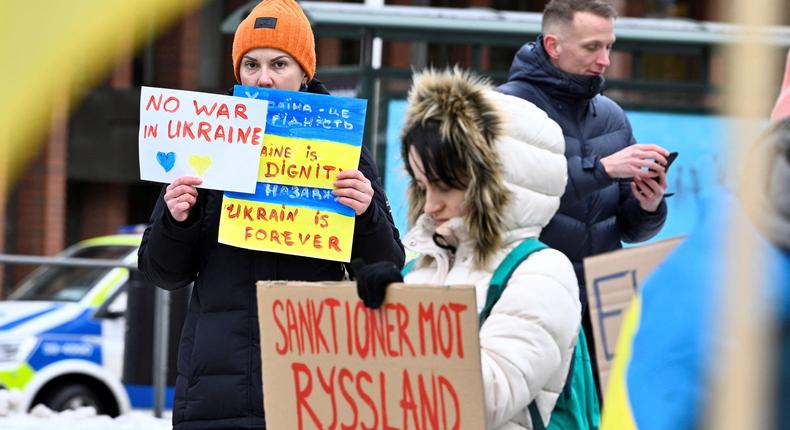 A protester holds a poster reading Sanctions against Russia now during a rally in front of the Russian Embassy in Stockholm on February 24, 2022, after Russia launched military operations in Ukraine.