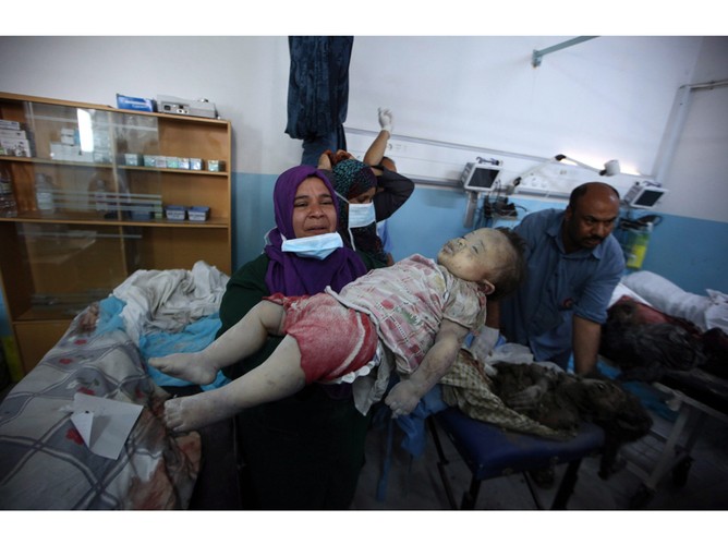 Libijska pielegniarka z ciałem zabitego malego dziecka. Wedlug rządu Libijskiego dziecko jest ofiarą nalotów NATO. Libia, 20 czerwca 2011