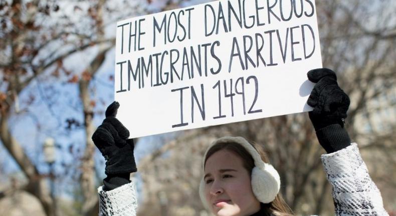 A demonstrator holds a sign near the White House to protest President Donald Trump's travel ban on six Muslim countries