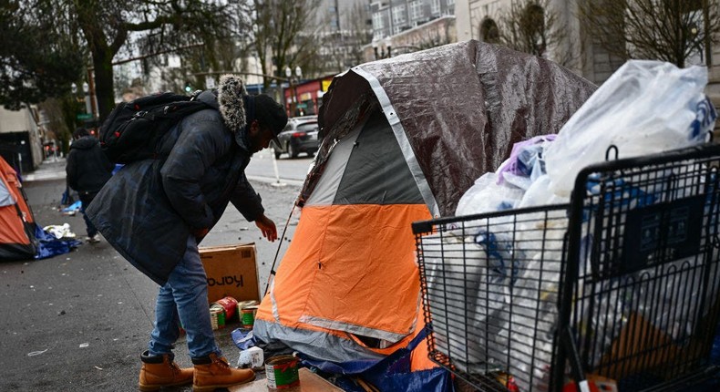 An outreach supervisor speaks to a person in a tent in Portland, Oregon.Getty Images