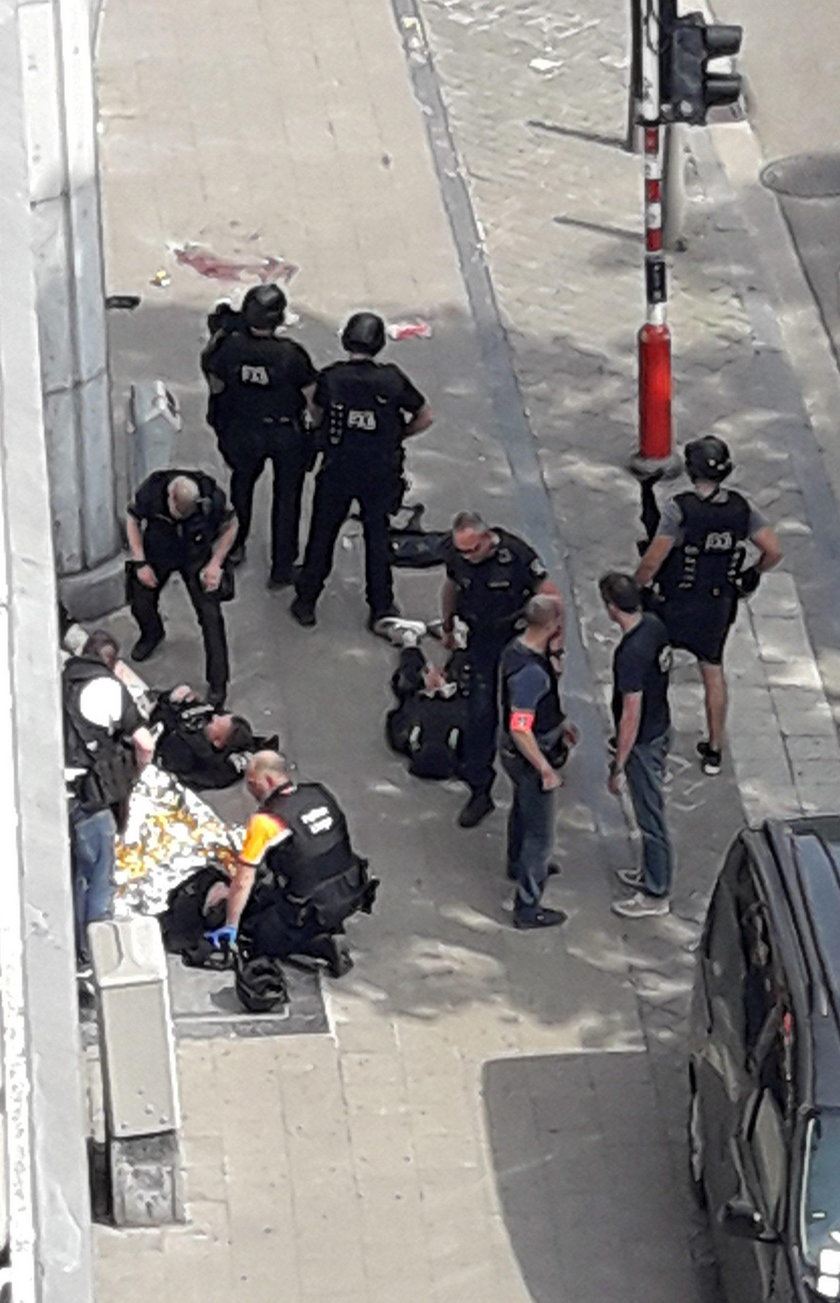 Police special forces are seen next to a man lying on the pavement and who supposedly was the shoote