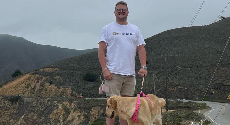 Nova AI founder Zach Smith stands with his dog on the top of a mountainZach Smith
